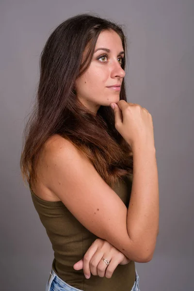 Retrato de jovem bela mulher contra fundo cinza — Fotografia de Stock