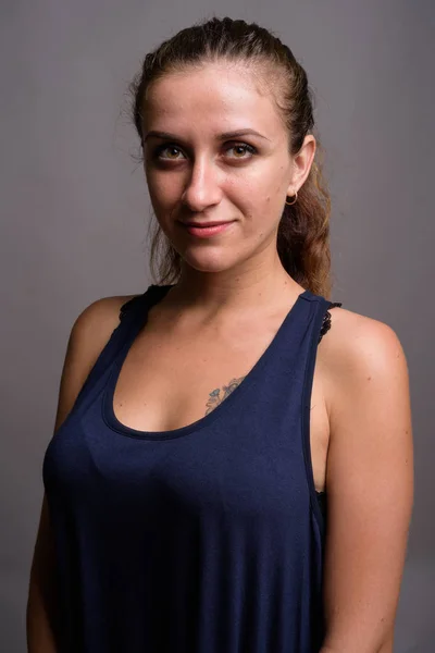 Retrato de joven hermosa mujer sobre fondo gris — Foto de Stock