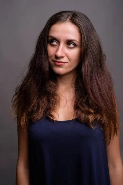 Retrato de jovem bela mulher contra fundo cinza — Fotografia de Stock