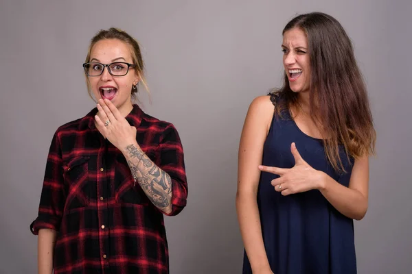 Portrait de deux jeunes belles femmes sur fond gris — Photo