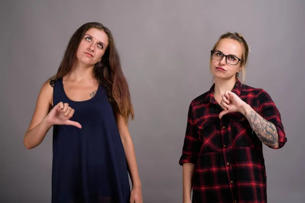 Portrait de deux jeunes belles femmes sur fond gris — Photo