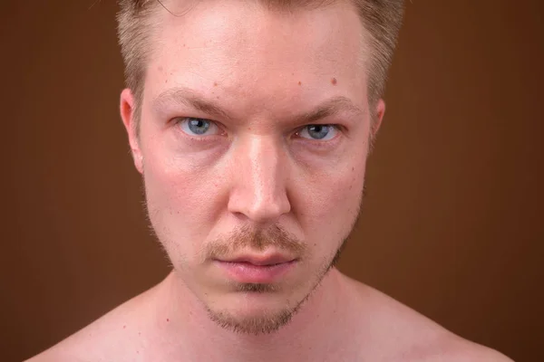 Retrato de cara de jovem contra fundo marrom — Fotografia de Stock