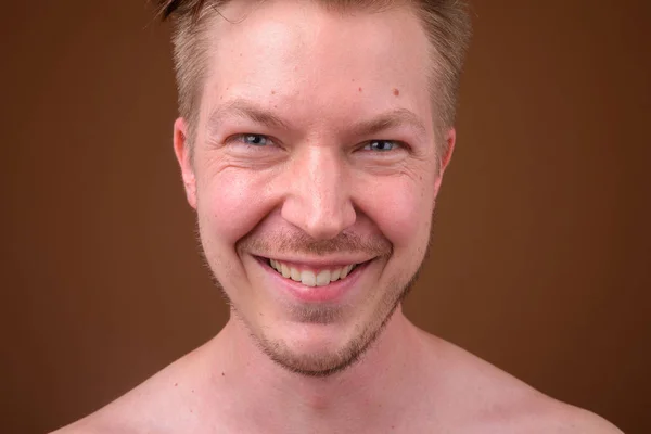 Retrato de joven sonriente cara contra fondo marrón —  Fotos de Stock