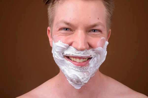 Volto di giovane uomo che si depila il viso sorridendo — Foto Stock