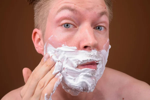 Gesicht des jungen Mannes rasiert sich das Gesicht — Stockfoto