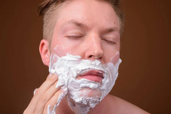 A fiatalember arca borotválkozás arc — Stock Fotó