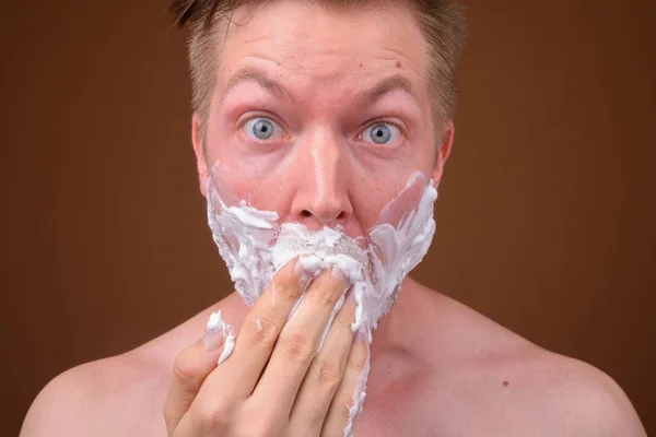 A fiatalember arca borotválkozás arc — Stock Fotó