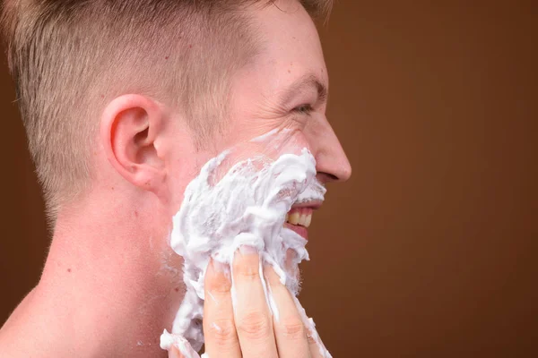 Профиль лица молодого человека, бреющего лицо — стоковое фото