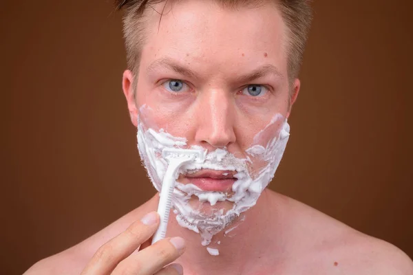 Лицо молодого человека, бреющего лицо — стоковое фото