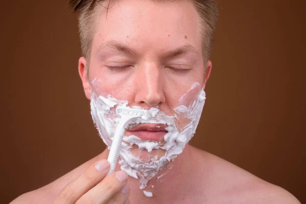 Лицо молодого человека, бреющего лицо — стоковое фото