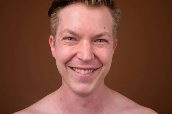 Mosolygós barna háttér boldog fiatalember portréja — Stock Fotó