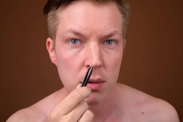 Retrato de homem pegando e removendo seus pêlos do nariz — Fotografia de Stock