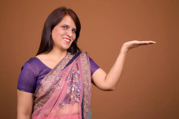 Felice donna indiana indossando vestiti tradizionali e mostrando spazio copia — Foto Stock
