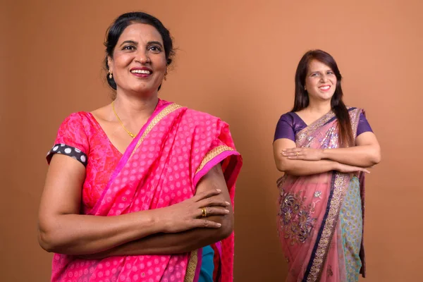 Two confident Indian woman smiling with arms crossed