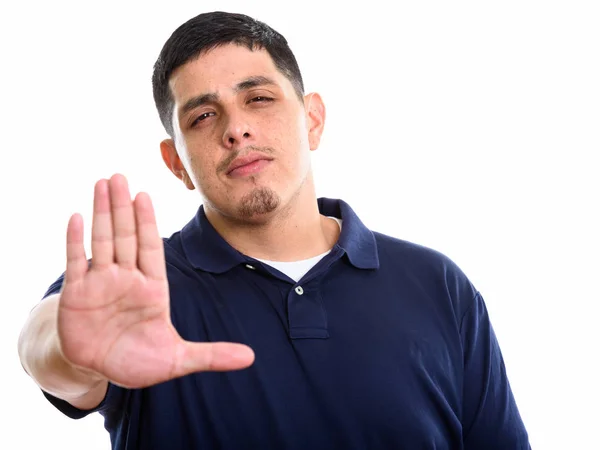 Studio skott av ung latinamerikan man med stop hand gest — Stockfoto