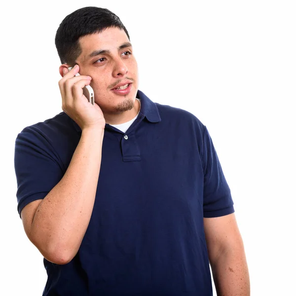 Студийный снимок молодого латиноамериканца, разговаривающего по мобильному телефону — стоковое фото