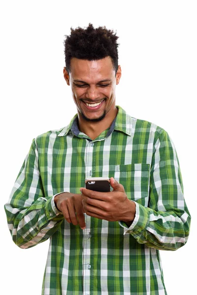 Estúdio tiro de jovem feliz homem africano sorrindo ao usar mobil — Fotografia de Stock