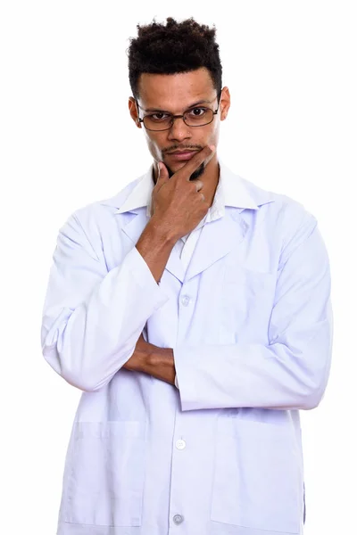 Studio shot of young African man doctor thinking with hand on ch — Stock Photo, Image