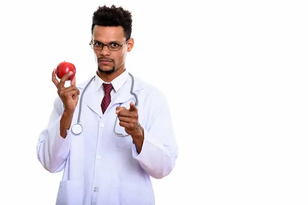 Joven africano médico sosteniendo manzana roja mientras señala a cam — Foto de Stock