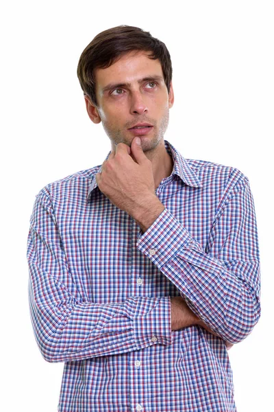 Studio shot of young handsome businessman thinking while looking — Stock Photo, Image