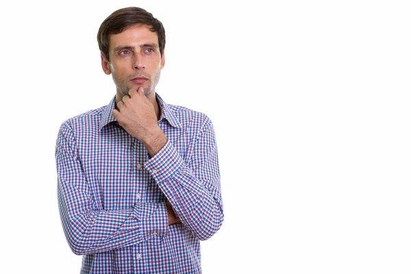 Studio shot of young handsome businessman thinking while looking — Stock Photo, Image