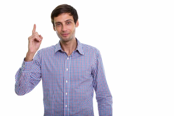 Studio shot of young handsome businessman pointing finger up — Stock Photo, Image