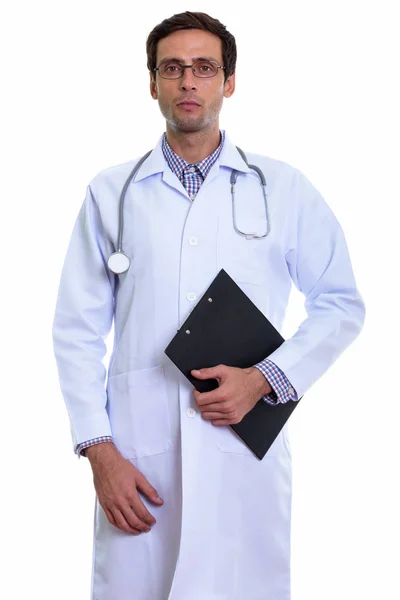 Studio shot of young handsome man doctor standing while holding — Stock Photo, Image