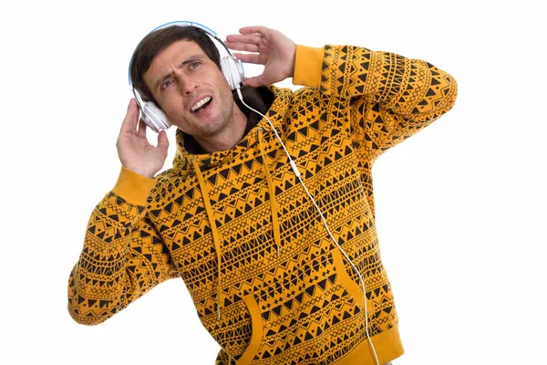 Студійний знімок вдумливого молодого чоловіка, який слухає музику і лоокі — стокове фото
