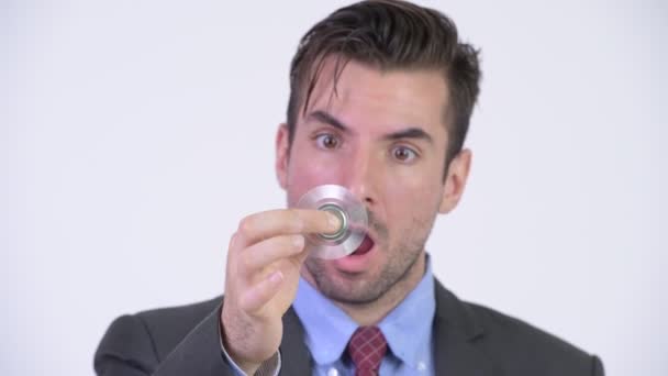 Young happy Hispanic businessman playing with fidget spinner — Stock Video