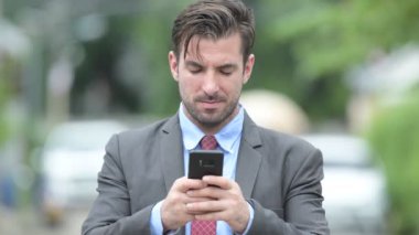 Telefonunuzun ve açık havada Genç mutlu İspanyol işadamı