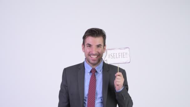 Young happy Hispanic businessman with selfie paper sign — Stock Video