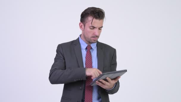 Jonge Spaanse zakenman met behulp van digitale tablet en op zoek geschokt — Stockvideo