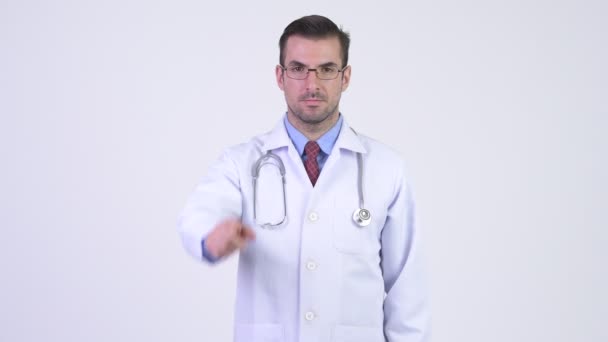 Młody szczęśliwy człowiek Hiszpanie lekarz wskazując na aparat — Wideo stockowe