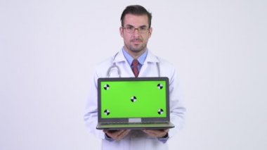 Dizüstü bilgisayarı gösteren genç mutlu Hispanik erkek doktor