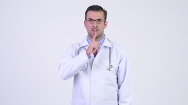 Молодой латиноамериканец доктор с пальцем на губах — стоковое видео