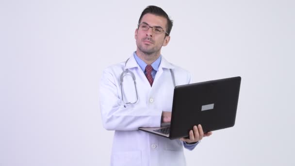Молодий щасливі іспаномовні чоловік лікар мислення при використанні ноутбука — стокове відео