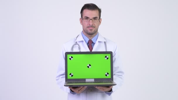 노트북을 보여주는 젊은 행복 히스패닉 남자 의사 — 비디오