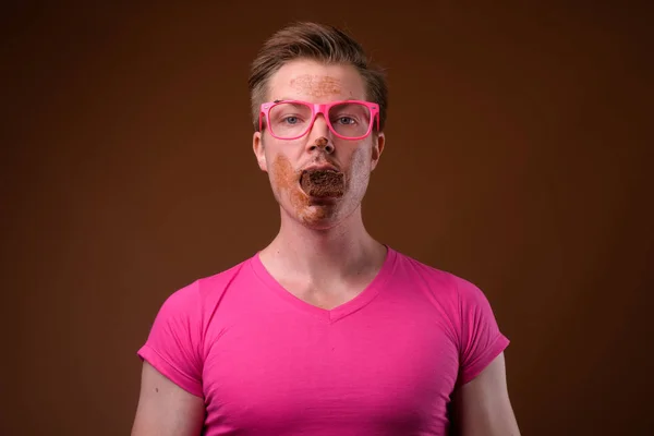 Joven hombre guapo con camisa rosa y anteojos contra bro —  Fotos de Stock