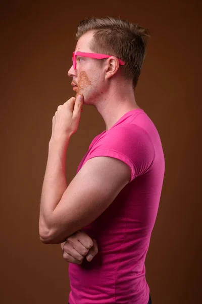 Giovane bell'uomo che indossa camicia rosa e occhiali contro bro — Foto Stock