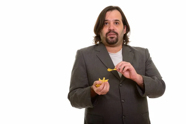 Gordo caucásico hombre de negocios comiendo bocado de patatas fritas —  Fotos de Stock