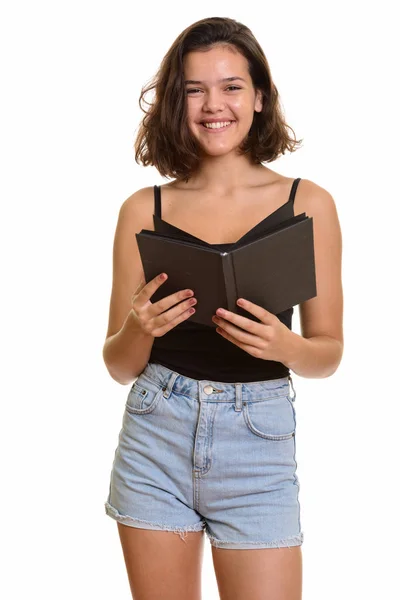 Jovem feliz caucasiano adolescente menina sorrindo enquanto segurando livro — Fotografia de Stock