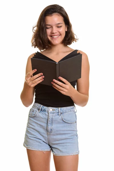 Genç mutlu beyaz kız gülümsüyor ve kitap okuyor. — Stok fotoğraf
