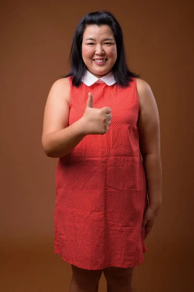 Vackra överviktiga asiatisk kvinna ler och ger tummen upp — Stockfoto