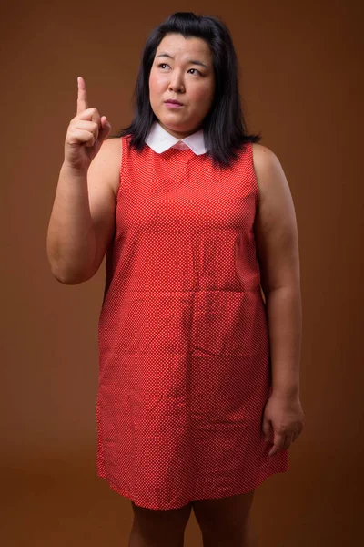 Vackra överviktiga asiatisk kvinna tänka och pekar finger — Stockfoto