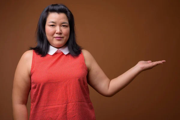 Linda mulher asiática com sobrepeso mostrando espaço de cópia — Fotografia de Stock