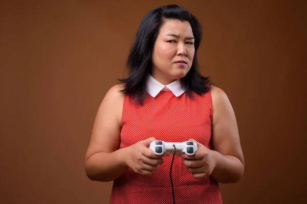 Linda mulher asiática com sobrepeso jogando jogos de vídeo usando controlador de jogo — Fotografia de Stock