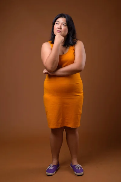 Full length colpo di bella donna asiatica in sovrappeso pensando — Foto Stock