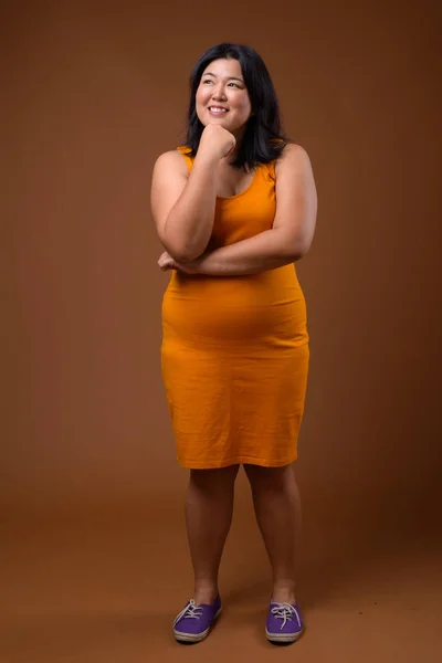 Feliz mujer asiática con sobrepeso pensando y sonriendo —  Fotos de Stock