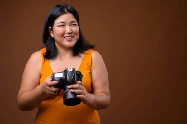 Belo excesso de peso mulher asiática fotógrafo pensamento e planejamento — Fotografia de Stock
