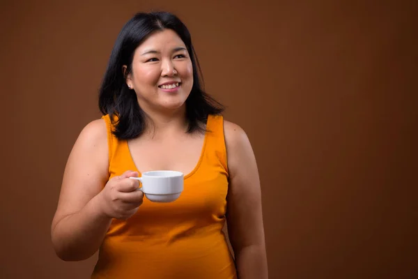 Hermosa mujer asiática con sobrepeso sosteniendo taza de café —  Fotos de Stock